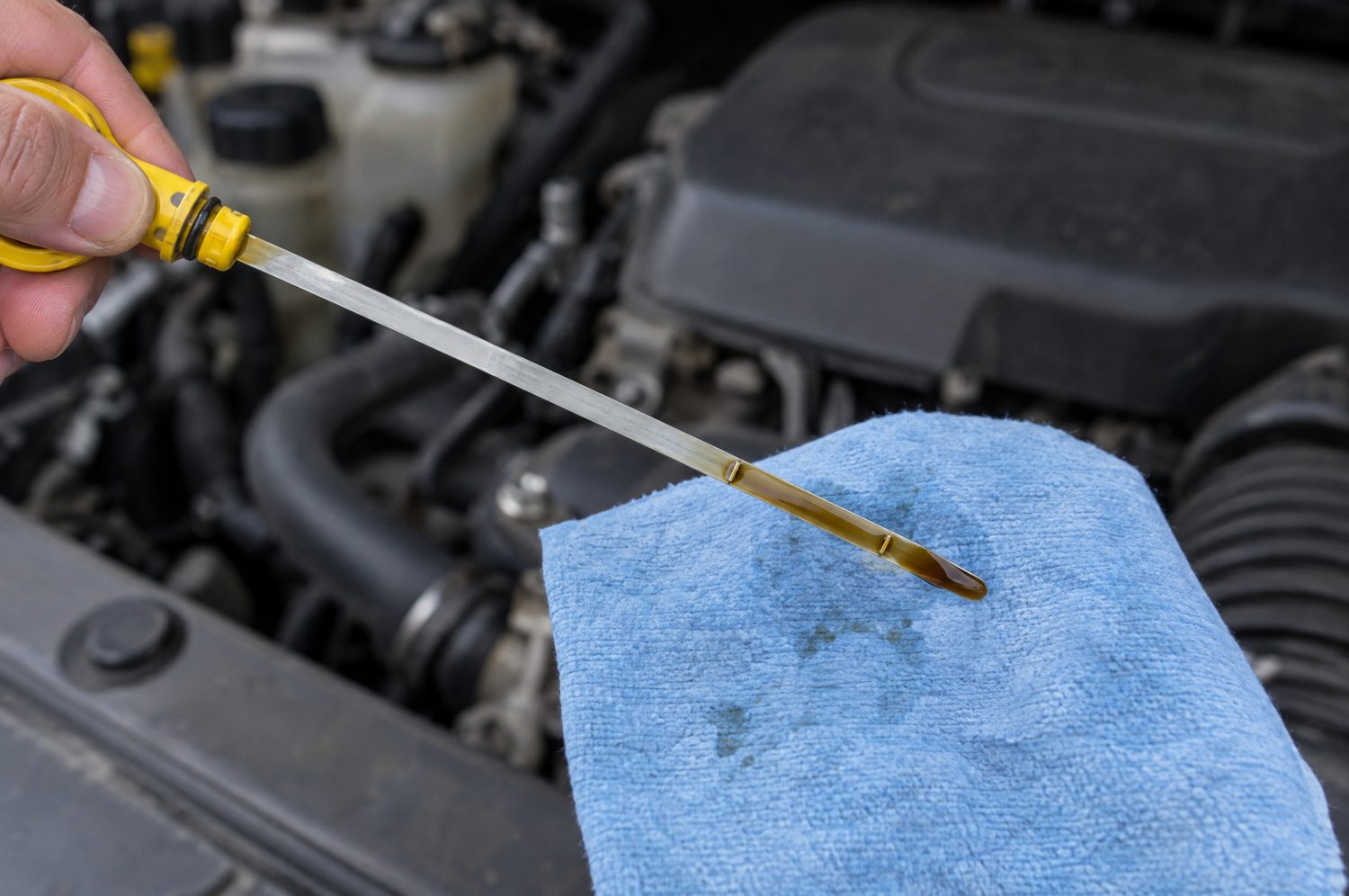 Oliepeilstok uit de motor getrokken om het oliepeil af te lezen