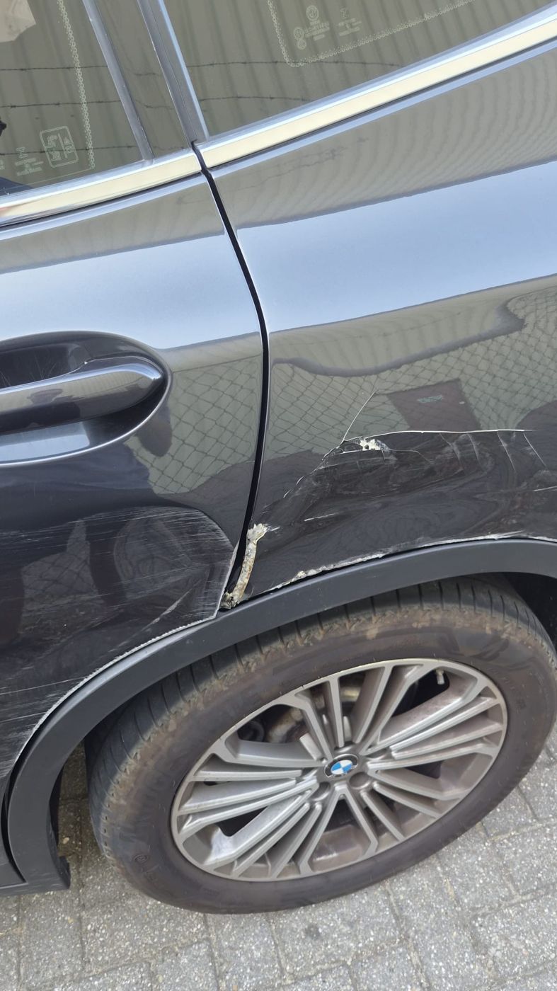 BMW X3 met krassen en een ingescheurd zijscherm bij het achterportier