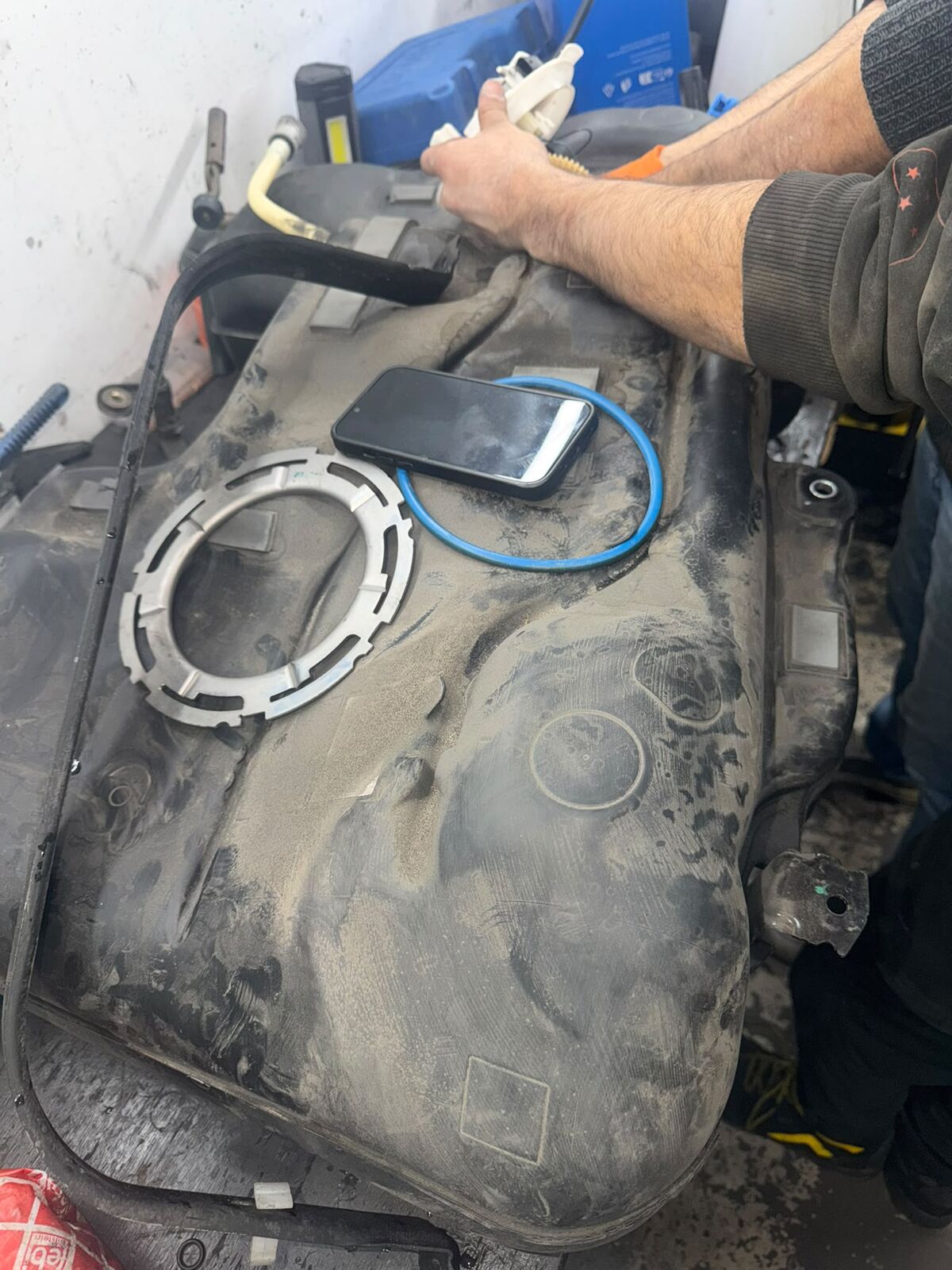 De brandstoftank op de werkbank met de sluitring en de blauwe afdichtring ernaast