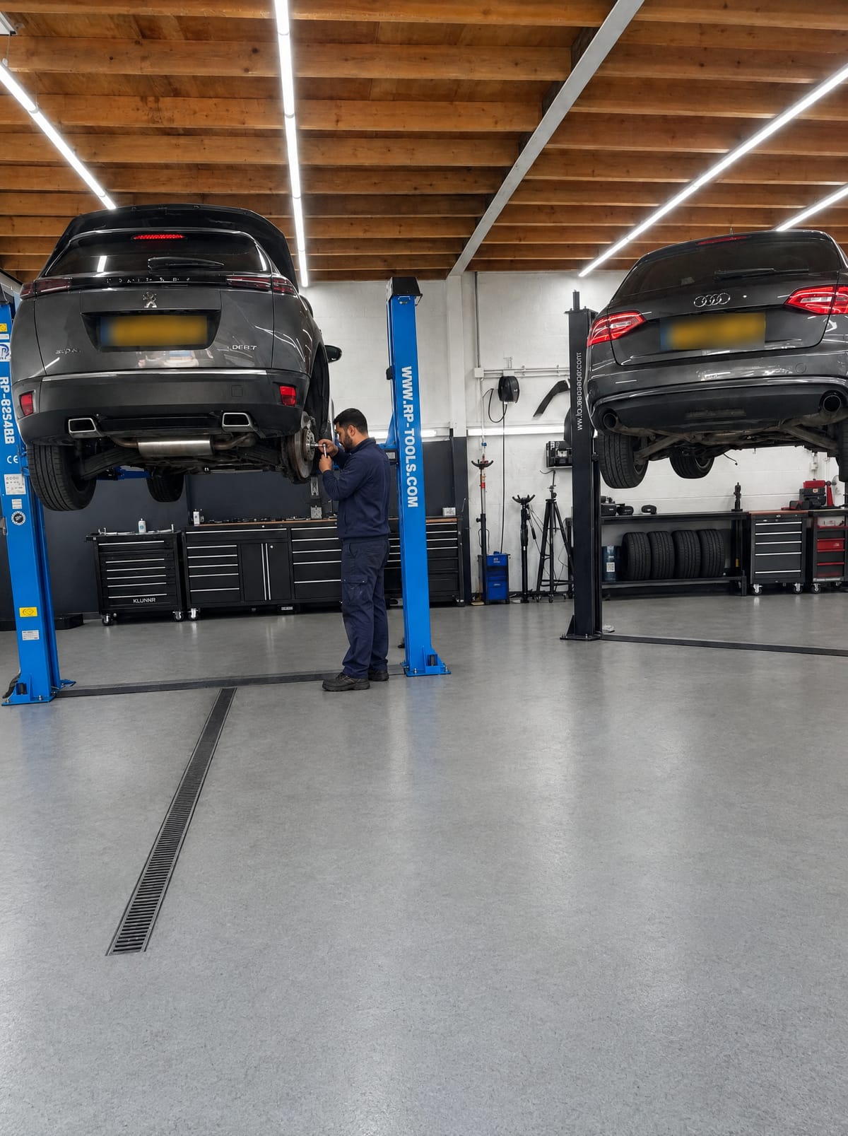 Twee auto's op de brug in de werkplaats van MT Autoservice